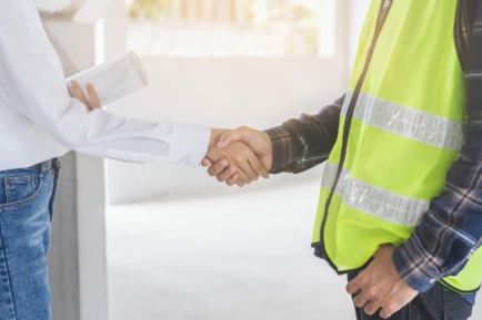 Engineer team building, teamwork contractor, two asian young partnership, builder agreement handshake plan home project contract at construction site .Happy architect, surveyor worker shaking hand.